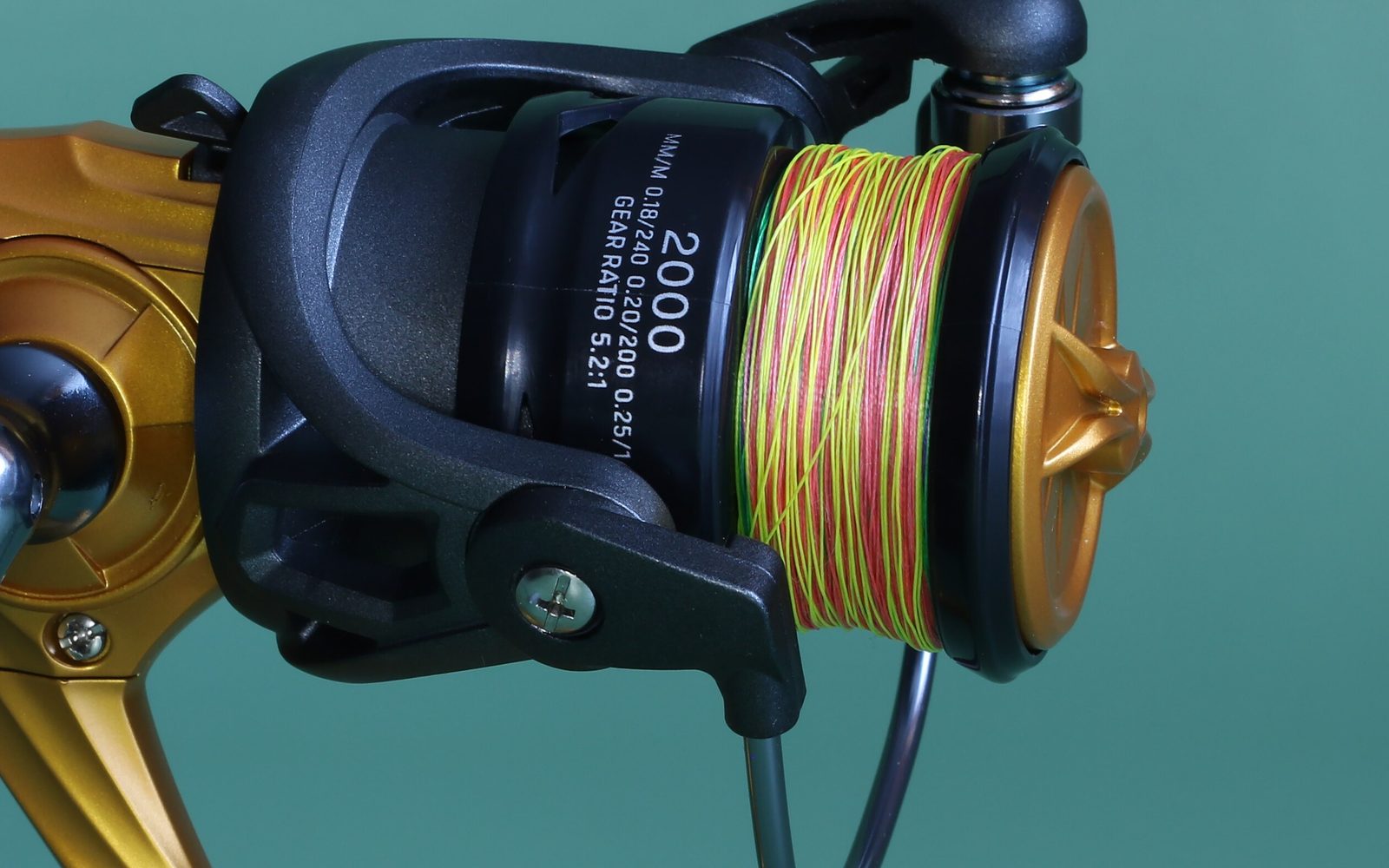 Spinning reel spool wound with braided fishing line, with the line diameter and capacity printed on the spool